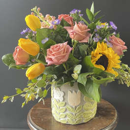 Bouquet of pink roses and yellow tulips in a decorative ceramic vase