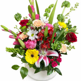 Mixed bouquet in a white vase with roses, lilies, and daisies