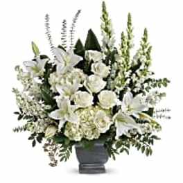 White lilies and roses arranged in a dark vase