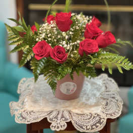 Pink rose arrangement in a small pot with baby's breath