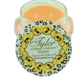 A scented candle in a glass jar with a decorative label.