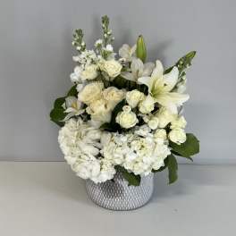 White floral arrangement in a patterned gray vase