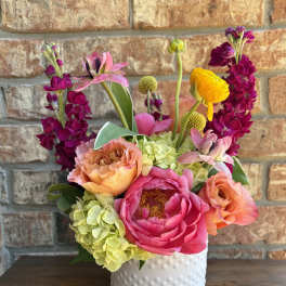 Bright mixed bouquet in a white textured vase