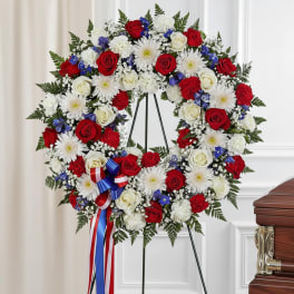 Heart-shaped funeral wreath of red and white roses with white daisies on an easel