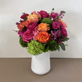 Bright mixed bouquet of roses in a white vase