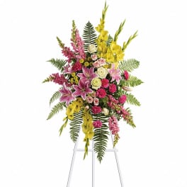 Tall standing floral spray with pink, yellow, and white flowers on an easel