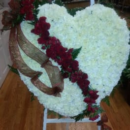 Heart-shaped white floral arrangement with a red rose diagonal and ribbon