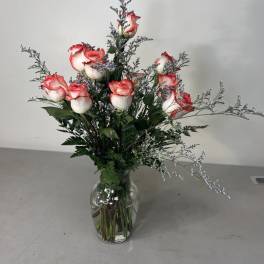 Pink-edged white roses arranged in a clear glass vase