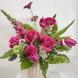 Pink roses and gerbera daisies in a pale vase