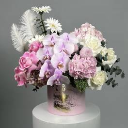 Pink and white floral arrangement in a pink cylindrical box