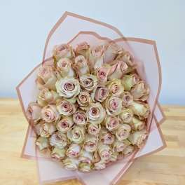 Bouquet of pale pink roses wrapped in translucent pink paper