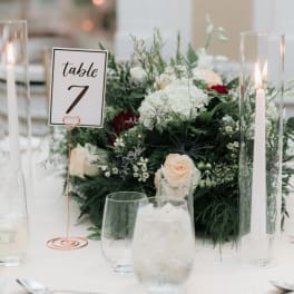 White and blush floral centerpiece with table number and tall candles