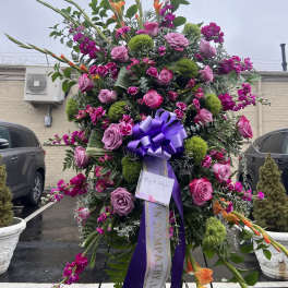 Large standing floral spray with pink roses and purple ribbon