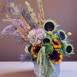 Sunflowers and pastel hydrangeas arranged in a glittery vase
