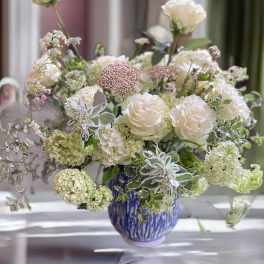 White roses and pale blooms in a blue vase