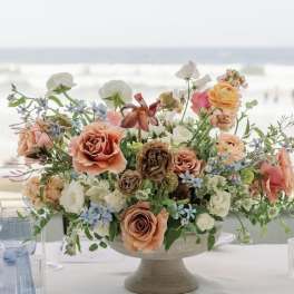 Peach and white floral centerpiece in a pedestal bowl