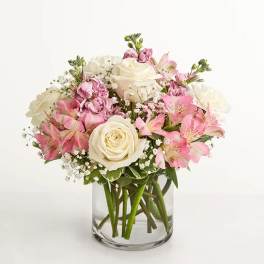 Pink and white bouquet of roses and lilies in a clear glass vase