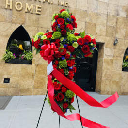 Standing red floral spray with a pink ribbon on an easel