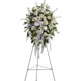 White floral standing spray on an easel with ribbon