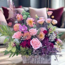 Pink and peach floral arrangement in a silver rectangular container
