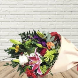 Mixed bouquet with lilies, roses, and chrysanthemums wrapped in paper