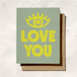 A greeting card with a yellow eye icon and the words LOVE YOU