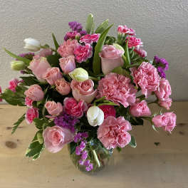 Pink roses and carnations arranged in a glass vase