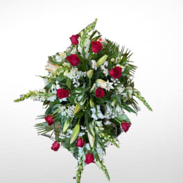 Standing floral spray with red roses, white lilies, and greenery