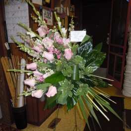 Standing floral spray with pink roses and tall white blooms on an easel