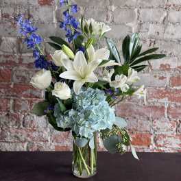 Blue and white floral arrangement in a clear glass vase