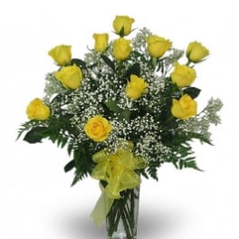 Yellow roses in a clear glass vase with baby's breath