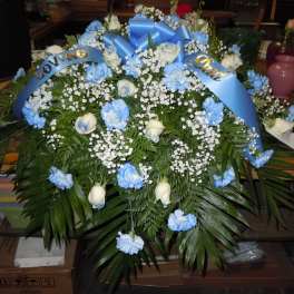 Blue and white floral funeral spray with ribbon banners
