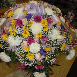 Large mixed flower funeral spray with white ribbon