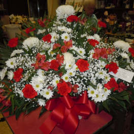 Large red, white, and pink floral spray with a red ribbon bow