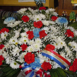 Large red, white, and blue floral wreath with ribbon