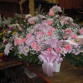 Large pink and white floral arrangement with a pink ribbon and "Grandma" sign