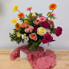 Mixed bouquet of roses and gerbera daisies in a glass vase