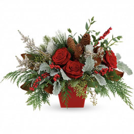 Red roses in a red container with pinecones and winter greenery