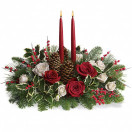 Holiday centerpiece with red candles, roses, pinecones, and evergreen branches