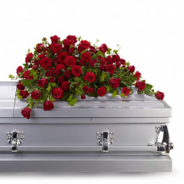 Red roses and carnations arranged on a silver casket