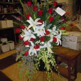 Tall floral spray with red roses and white lilies on a stand