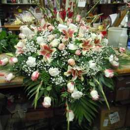 Large floral spray with pink lilies, white roses, and red gladiolus