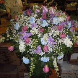 Large mixed floral arrangement with pink roses, blue carnations, and white baby's breath
