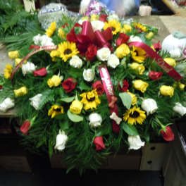 Large floral spray with red, yellow, and white roses and sunflowers