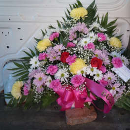 Large mixed flower spray with pink ribbon and red roses