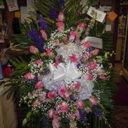 Large standing floral spray with pink roses, hydrangeas, and purple flowers