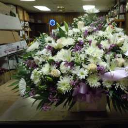 Large white and purple floral spray with a lavender ribbon