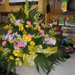 Large mixed floral arrangement with yellow, pink, and lavender blooms