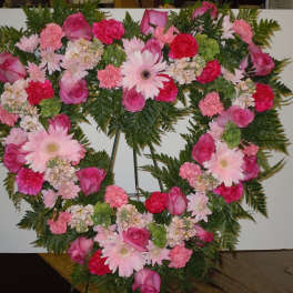 Heart-shaped floral wreath with pink roses and daisies