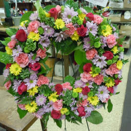 Heart-shaped floral wreath with pink, red, yellow, and lavender blooms